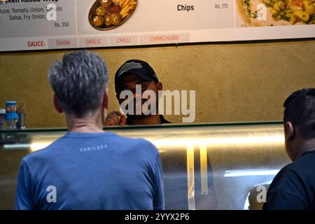 A Nepali chef serves tourists in his fast food restaurant in Thamel, Kathmandu, Nepal. Stock Photo