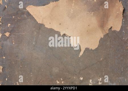 damaged or weathered paper background texture, brownish tone grunge ripped or peeling revealing lighter layer underneath surface, backdrop wallpaper Stock Photo