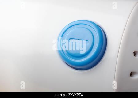 close-up of blue round button of a device or machinery on white surface background, control panel or remote switch in soft focus with copy space Stock Photo