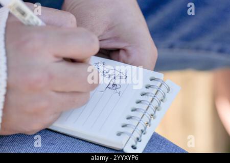 A couple in their 20s are sitting on a bench and talking in a large park in Handa City, Aichi Prefecture in autumn. Stock Photo