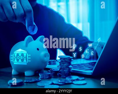CBDC, central bank digital currency concept. CBDC with digital circuit icon on piggy bank near money coin stacks, businessman calculating online money Stock Photo