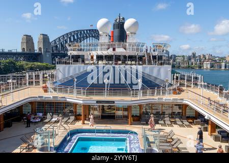 Cunard Queen Elizabeth cruise ship moored in Sydney Circular Quay with view of Pavilion pool on deck 9 and Sydney harbour bridge , Australia,2024 Stock Photo