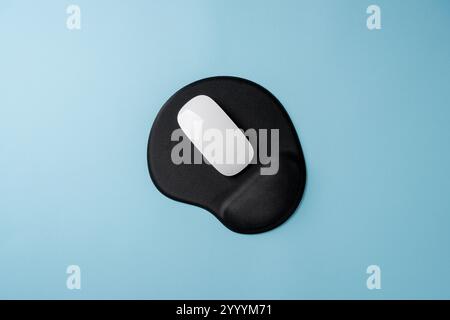 Top view of modern white mouse on black mousepad on blue table Stock Photo