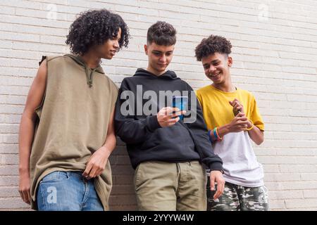 three diverse teens having fun using mobile phone Stock Photo