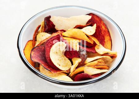 Bowl of mixed healthy vegetable chips isolated on a white background. Stock Photo