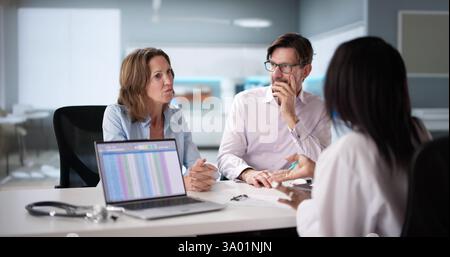 Happy African pregnant couple patient at doctor, talking about ultrasound.  Young black woman with diverse x-ray results, consulting nurse.  Mature Af Stock Photo