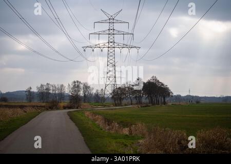 Dramatic sky over power pylons and fields Stock Photo