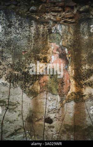 Layers of time revealed: A weathered wall with peeling paint, showing fragments of history and decay, found in a ruined church. Stock Photo