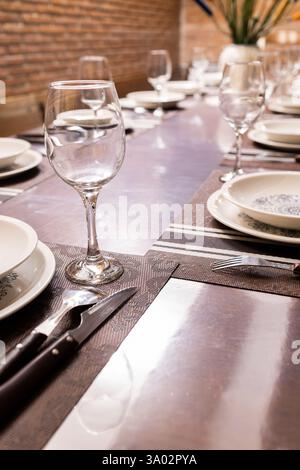 Elegantly set dining table with wine glasses and plates. Stock Photo
