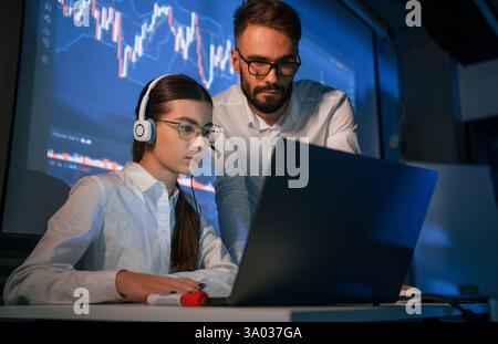 Man and woman is working in the office. Stock brokers using laptop. Stock Photo