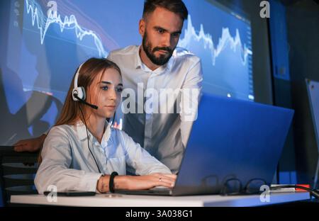 Man and woman is working in the office. Stock brokers using laptop. Stock Photo