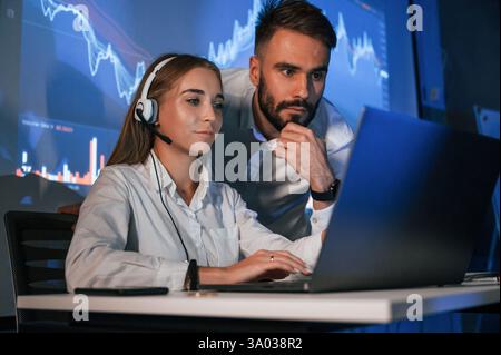 Man and woman is working in the office. Stock brokers using laptop. Stock Photo