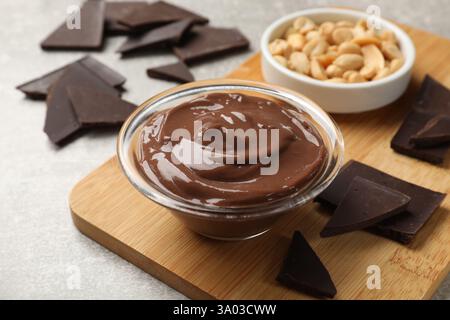 Delicious chocolate mousse in glass bowl and ingredients on grey table, closeup Stock Photo