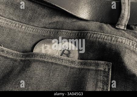 Two Bitcoin physical coins inside a blue jeans pocket Stock Photo