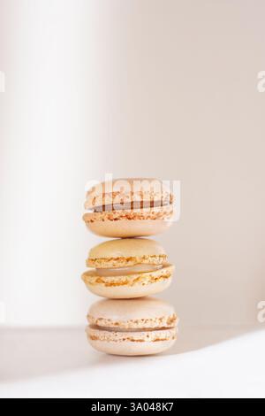 Three soft beige pastel macarons stacked Stock Photo