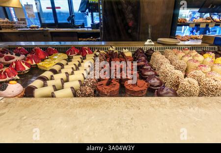 Beautiful array of assorted gourmet desserts in bakery showcase, featuring various colors, textures and decoration Stock Photo