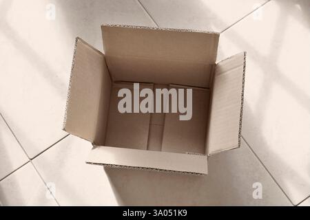 An opened empty brown cardboard box on the floor , e-commerce of packaging Stock Photo