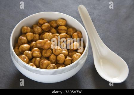 Indian breakfast fry chickpeas chana masala served in bowl with spoon on black background 12-May-2010 Stock Photo