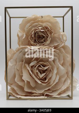 paper flowers on a golden metal stand. handmade beige paper roses. decoration. Stock Photo