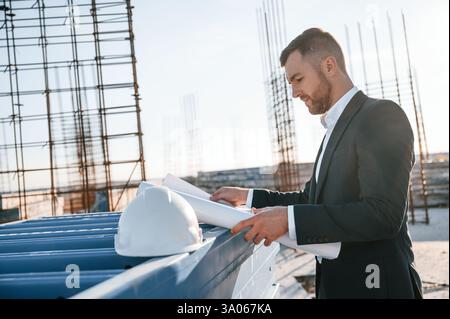 Businessman in formal clothes is on the construction site at daytime. Stock Photo