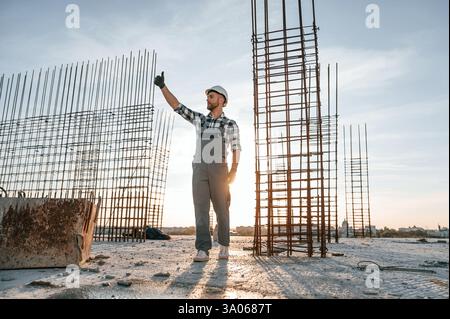 On construction site. Man in grey uniform is working. Stock Photo