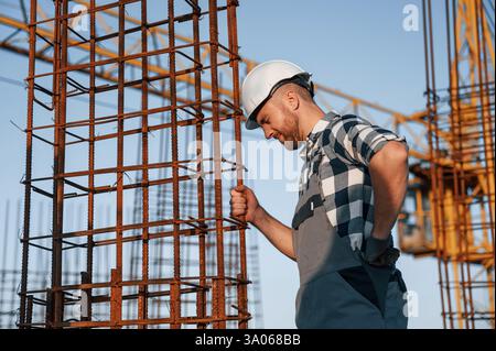 Feeling bad. Having headache. Man is working on the construction site at daytime. Stock Photo