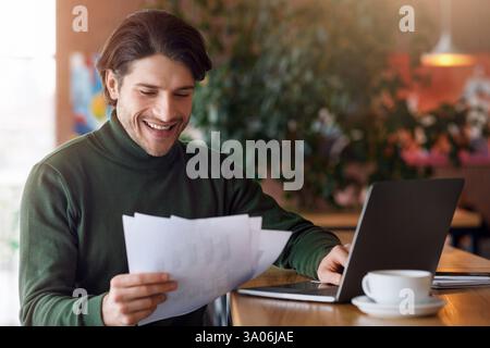 Happy man entrepreneur working with documents at cafe Stock Photo