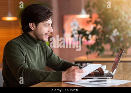 Journalist working on new article online at cafe Stock Photo