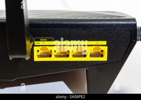 Close-up view of the yellow LAN ports on a home WiFi router against a white background Stock Photo