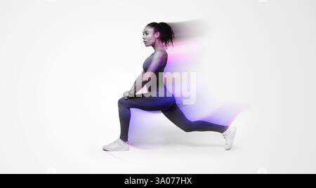 African American woman in activewear performing forward lunges on pink backdrop Stock Photo