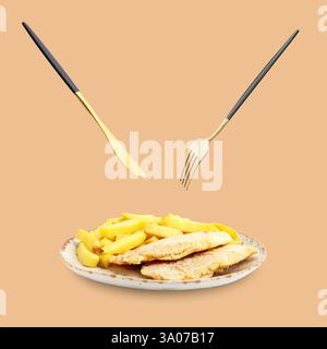 Cutlery in air over plate with delicious fish and chips on pastel brown background Stock Photo