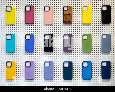 Multicolor of back covers for smartphone isolated on white peg board background. Colorful mobile phone case with empty space for camera lens, showing Stock Photo