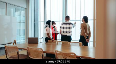 A diverse group of professionals engages in a brainstorming session in a sleek boardroom. The focus is on teamwork and innovation, as they develop new Stock Photo