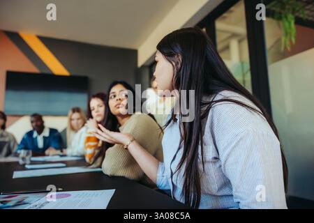 A group of students participates in a lively classroom discussion, exchanging ideas and fostering learning in an engaging academic environment. Stock Photo