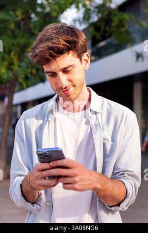 man using cell phone while walking down the street Stock Photo