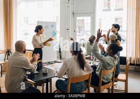 Multiracial male and female creative professionals discussing business strategies during office meeting Stock Photo