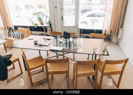 High angle view of empty meeting room with laptops and diary kept on table with drinking water in office Stock Photo
