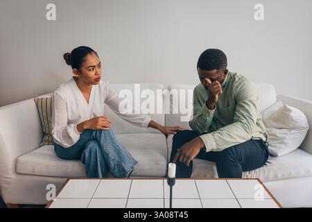 Businesswoman consoling stressed male colleague while sitting on sofa in office Stock Photo