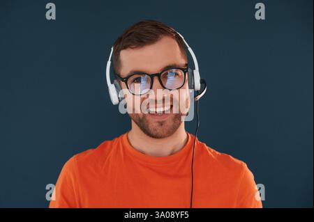 Handsome man is in the studio against blue background. Stock Photo
