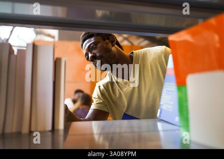 Male student choosing book from bookshelf in university library Stock Photo