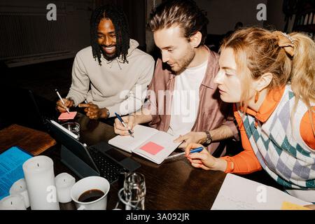 Male and female business professionals discussing over tablet PC while working at office Stock Photo