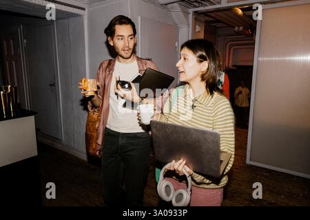 Male and female business professionals holding coffee cups and talking at office Stock Photo