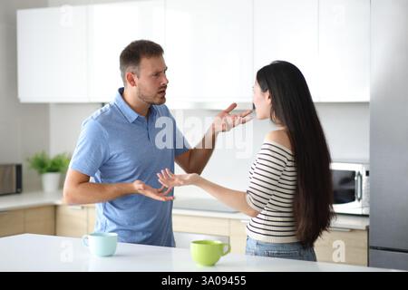 Interracial roommates arguing in the kitchen at home Stock Photo