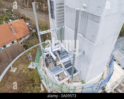 Workers on scaffolding assembling a platform on a high tower next to vegetation, staircase extension to the new tower of the Calw railway station on t Stock Photo
