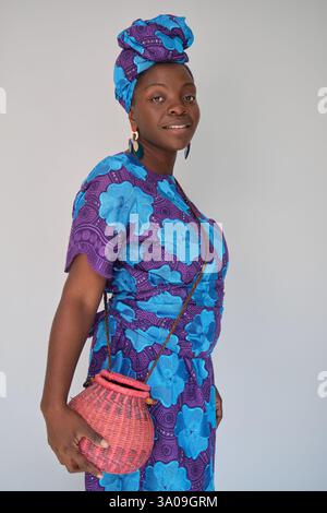 African woman wearing traditional clothes and a small wicker basket Stock Photo