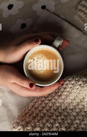 Female holding foamy cup of espresso Stock Photo