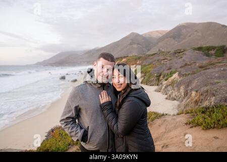 Happy couple enjoying the beautiful beach views Stock Photo