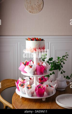 cupcakes and cake with berries on a stand Stock Photo