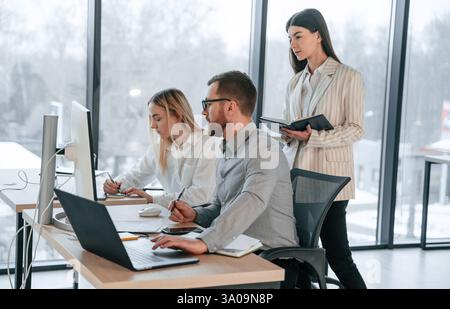 Using laptops. Successful team are working together in the office. Conception of business. Stock Photo