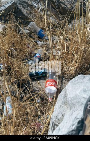 A bunch of empty soda bottles are scattered in a field Stock Photo